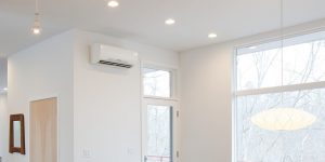 A modern living room with a ductless mini-split air conditioning unit mounted on the wall, providing cool air to the space.