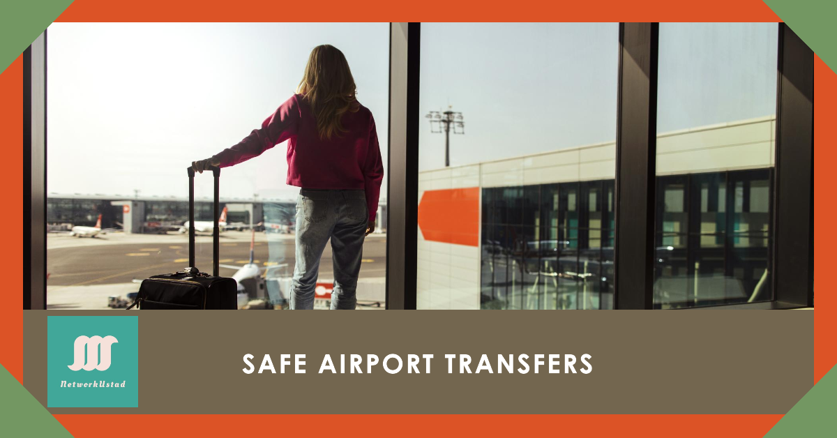 A person standing at an airport window with a suitcase, looking out at the runway and planes.