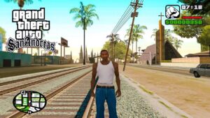 GTA San Andreas: A screenshot from the video game Grand Theft Auto: San Andreas showing the main character, CJ, standing in the middle of a street with palm trees and a railroad crossing in the background during daylight.