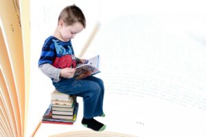 A young child sitting on a stack of books, reading a book, with an open book background. #Spelling Exercises
