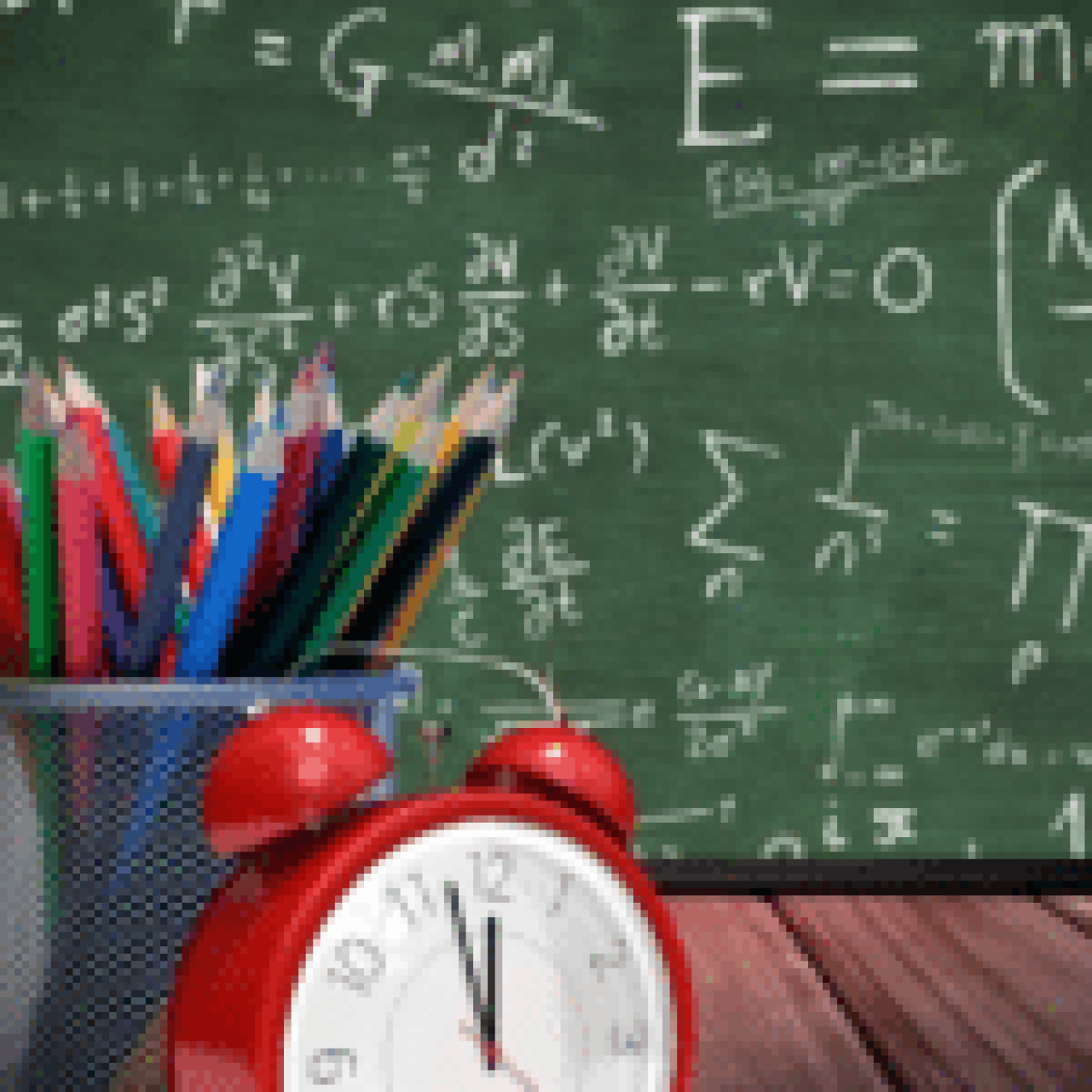 A vibrant array of colored pencils in a holder with a classic red alarm clock in front, set against a chalkboard filled with mathematical identities and equations.