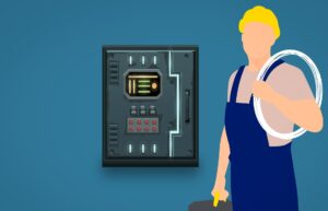 An electrician holding a coil of wire and standing next to an electrical panel.