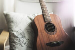 A close-up of an acoustic guitar with a wooden body and strings, highlighting the intricate details of the instrument.