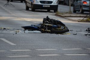 A wrecked motorcycle on an asphalt road after an accident, highlighting the need for a skilled accident lawyer.