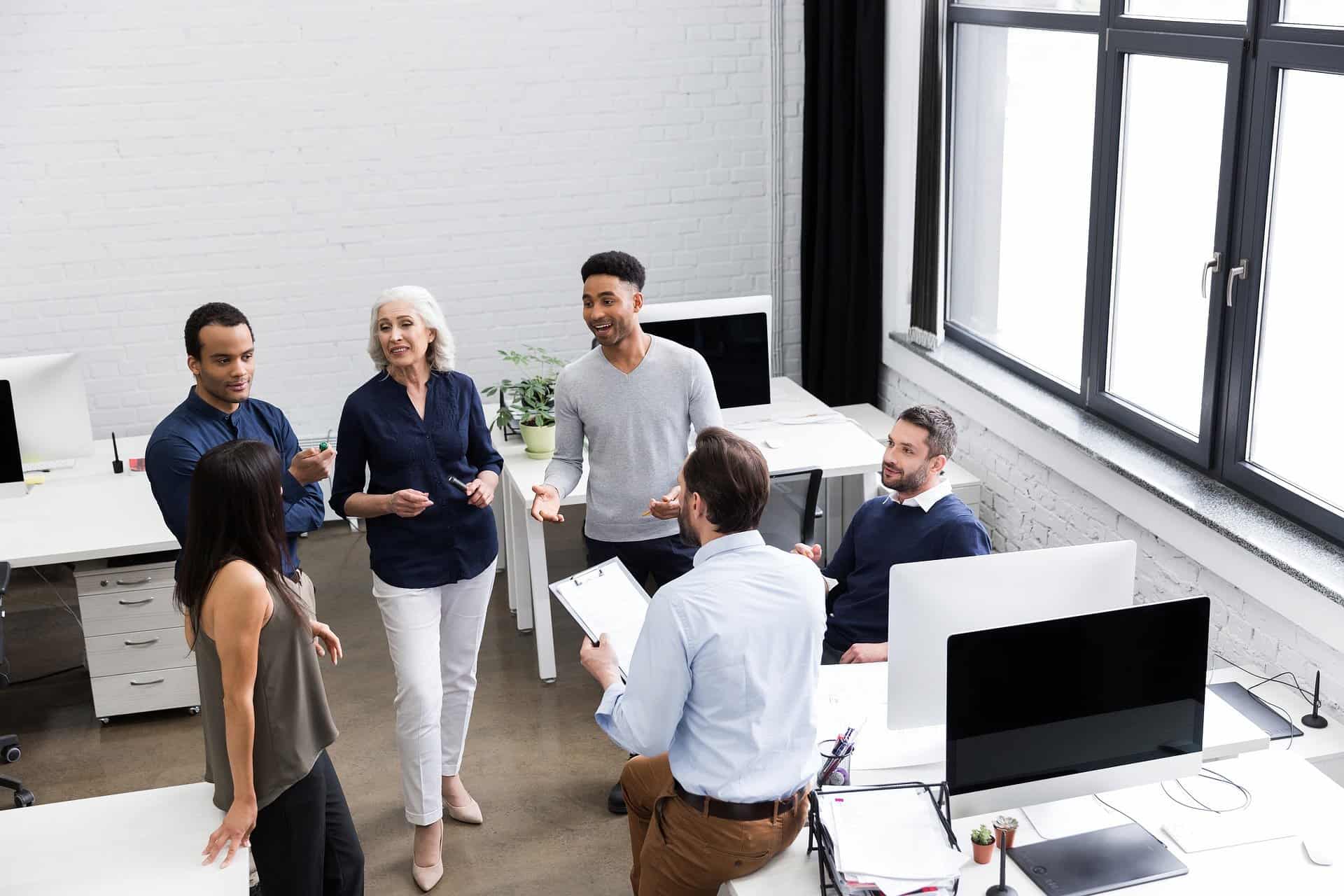 A group of professionals engaged in a collaborative discussion in a modern office setting, symbolizing teamwork and innovation. #Innovation Strategy