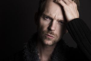A person looking concerned while reading a book about emotional abuse, highlighting the importance of awareness and understanding.
