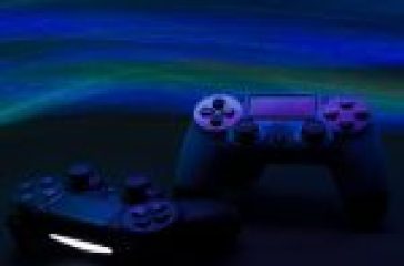 Two gaming controllers under blue ambient lighting with vibrant green and blue wave patterns in the background.