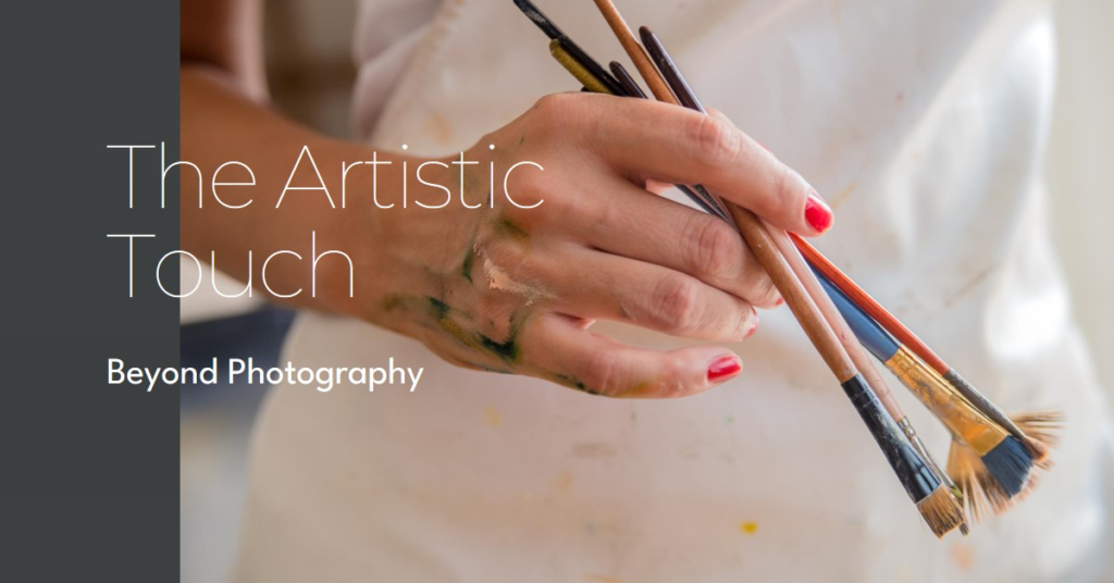 Close-up of a person’s hand holding multiple paintbrushes with paint stains on their fingers, suggesting the act of painting.