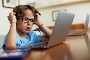 Individual using blue light glasses while working on a laptop
