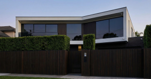 Modern home with privacy fence, hedges, and tinted windows for enhanced security