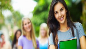 Person with books and papers around, representing research and writing.