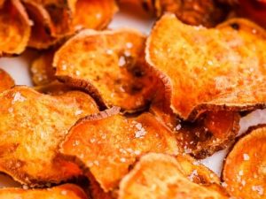 airfood recipe : Crispy Airfood potato bites in an air fryer basket with herbs, garlic, and paprika on a rustic kitchen counter.