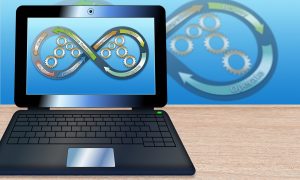 Laptop displaying an infinity symbol made of gears representing continuous sales automation processes.