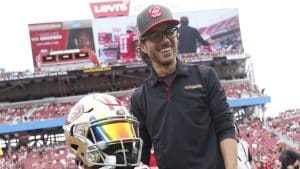 A person in a black 49ers polo shirt holds a football helmet at Levi’s Stadium.