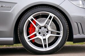 Close-up of a silver multi-spoke alloy wheel with red brake caliper on a car, highlighting superior quality.