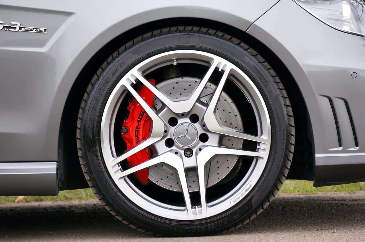 Close-up of a silver multi-spoke alloy wheel with red brake caliper on a car, highlighting superior quality.