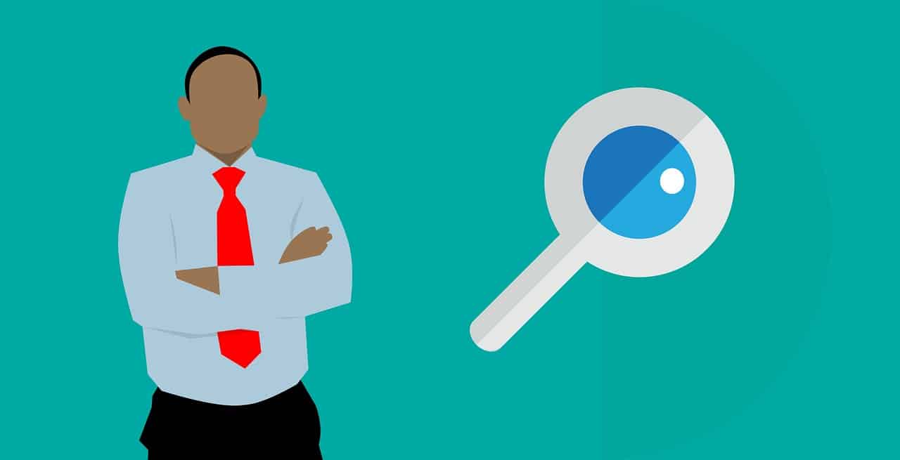 Illustration of a person in a suit with folded arms standing next to an oversized magnifying glass.