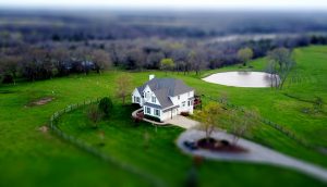 Aerial view of a two-story suburban home surrounded by greenery with selective focus. #Private Money Lending