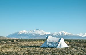 A cozy camping quilt draped over a sleeping bag inside a tent, symbolizing the warmth and comfort provided by camping quilts during outdoor adventures.