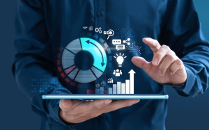 A person holding a tablet displaying digital marketing icons such as graphs and gears, symbolising online marketing analytics and strategy.