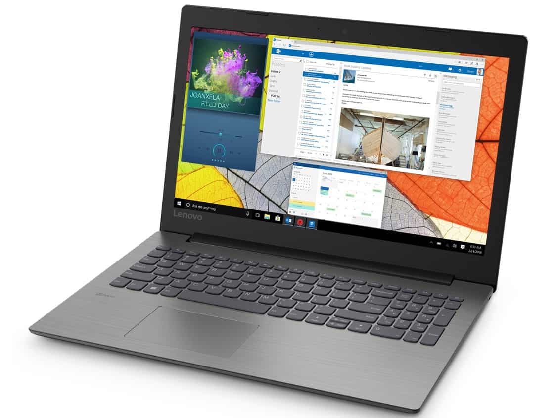 Lenovo IdeaPad 330-15 AMD laptop open on desk displaying vibrant wallpaper and multiple applications.