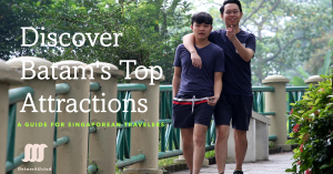 Two travelers exploring a lush green path in Batam with an informative overlay promoting a travel guide for Singaporean tourists.