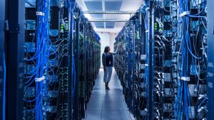 A modern data centers with row of server racks illuminated by blue and white lights, representing the backbone of business growth.
