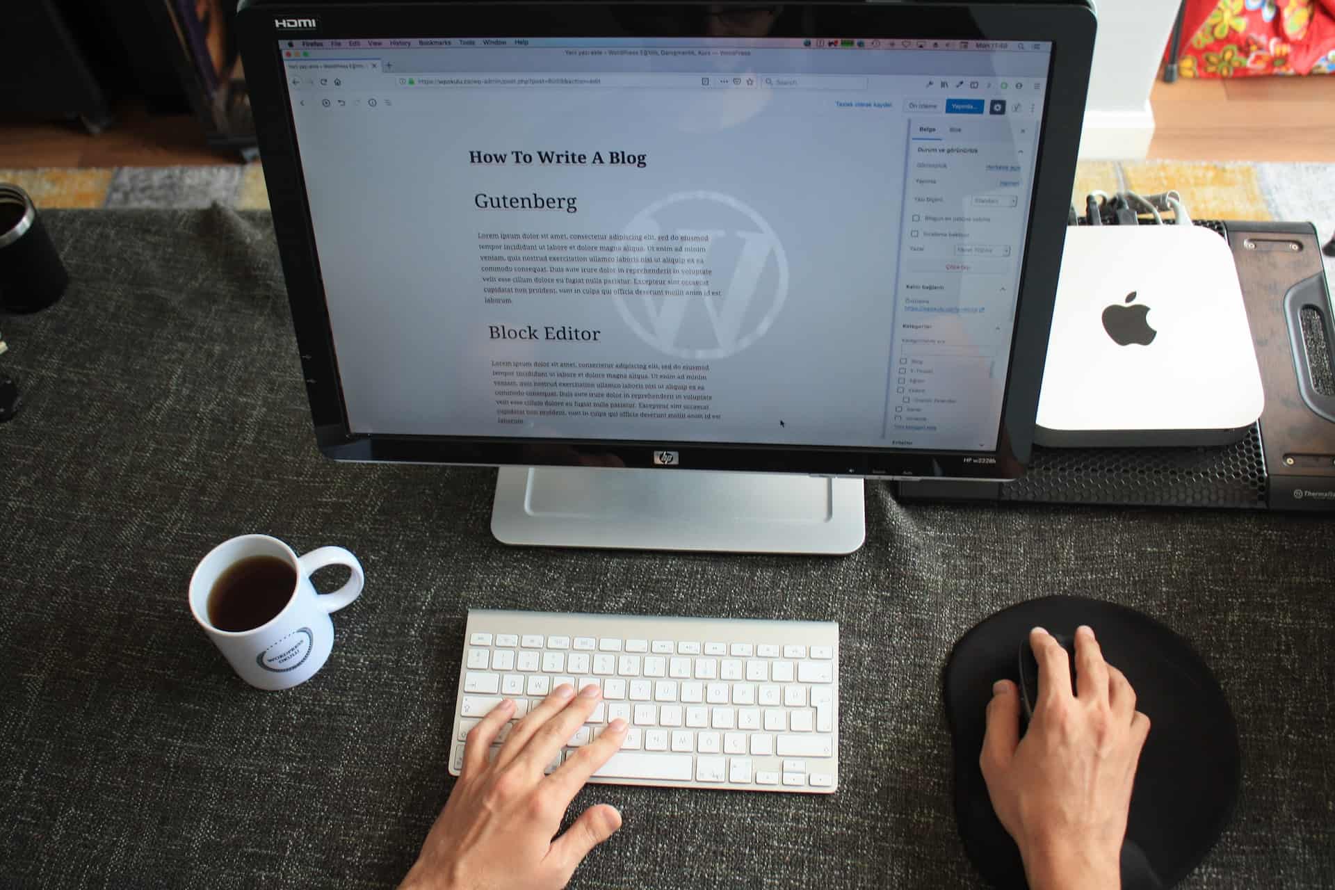 A person working on a blog post about writing blogs on a computer with WordPress open, indicating content creation for guest blogging.
