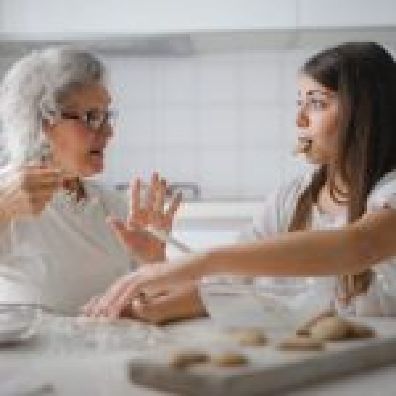 An elderly person and a young person baking together in a kitchen, illustrating the benefits of home care services.