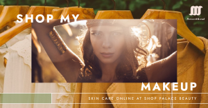 Woman applying makeup with a variety of skincare products arranged on a vanity table.