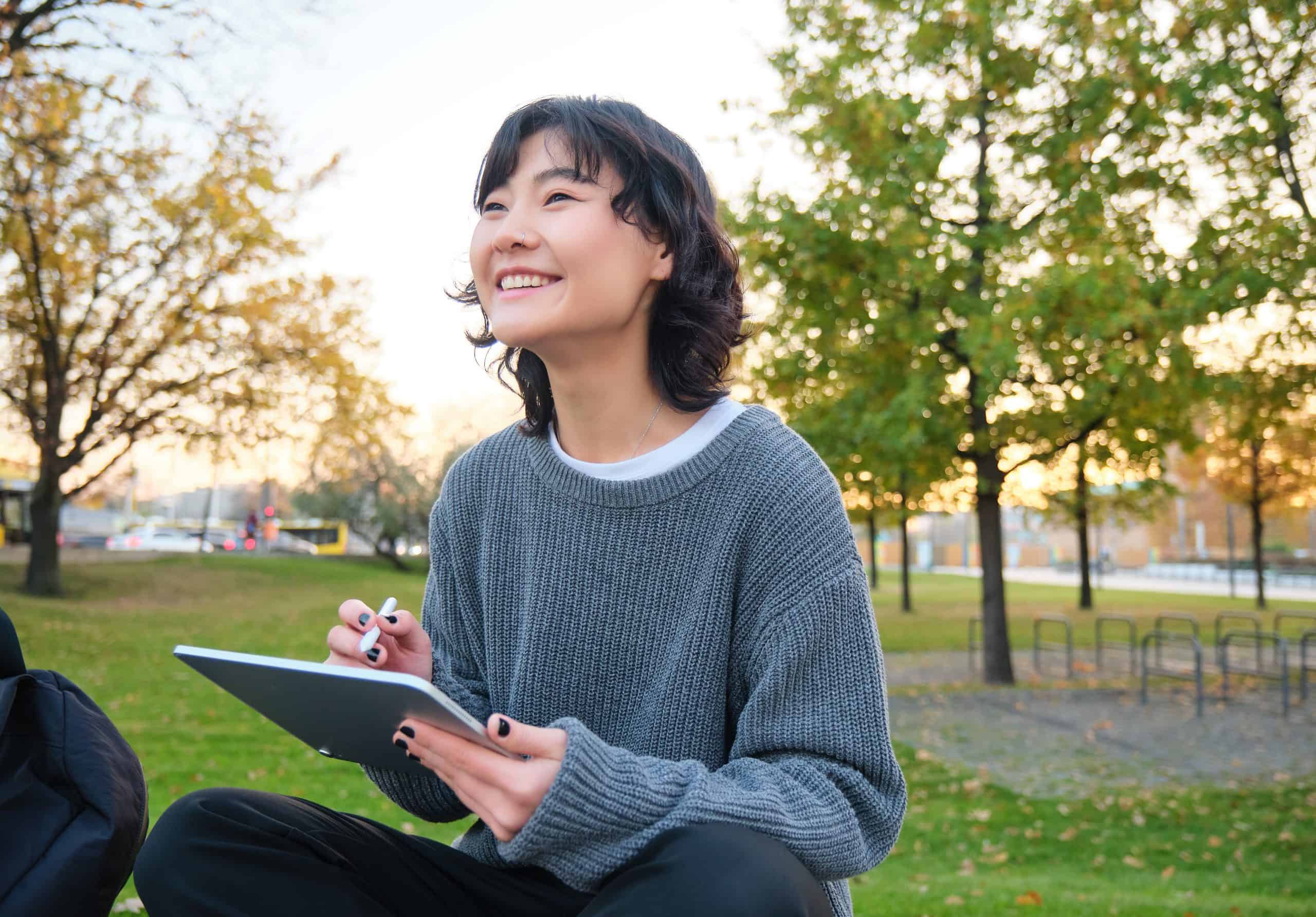 young korean woman sits in park draws on digital 2023 01 31 23 53 49 utc 1 scaled
