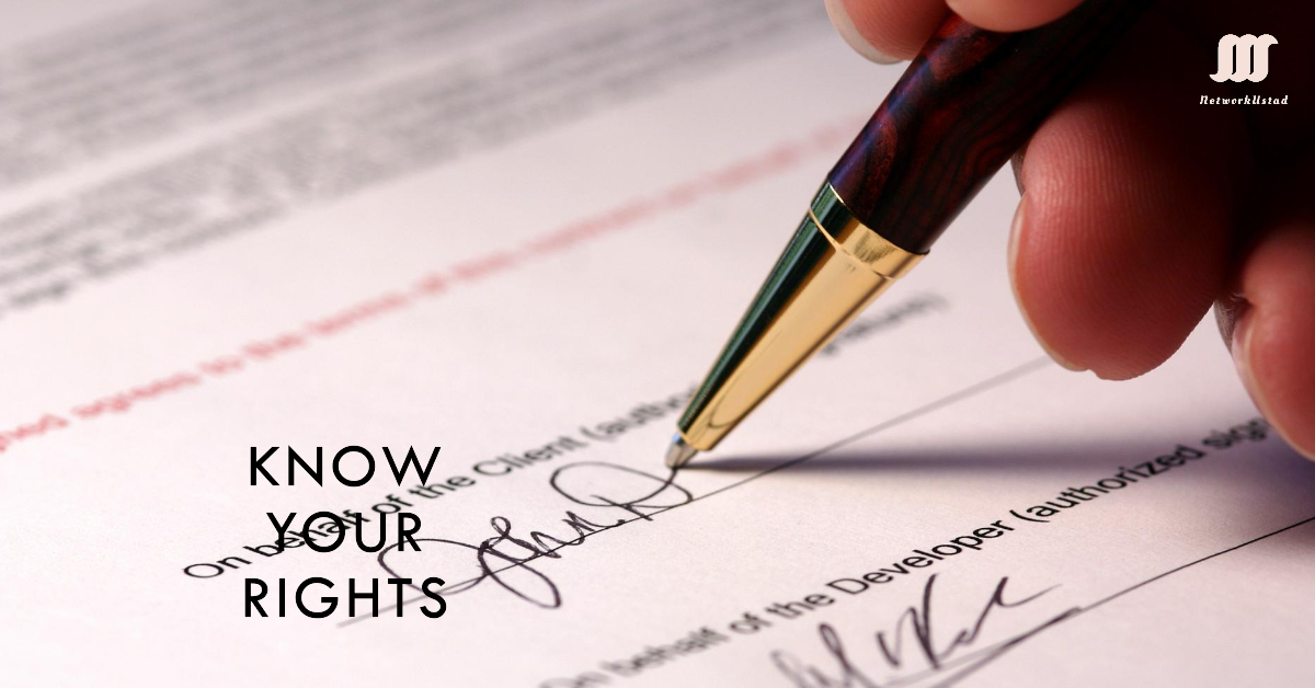 Close-up of a hand signing a formal document with the text "KNOW YOUR RIGHTS" in the corner.