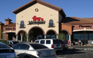 Exterior view of Fry’s Marketplace with clear signage, under a blue sky, flanked by other store fronts including a pharmacy.