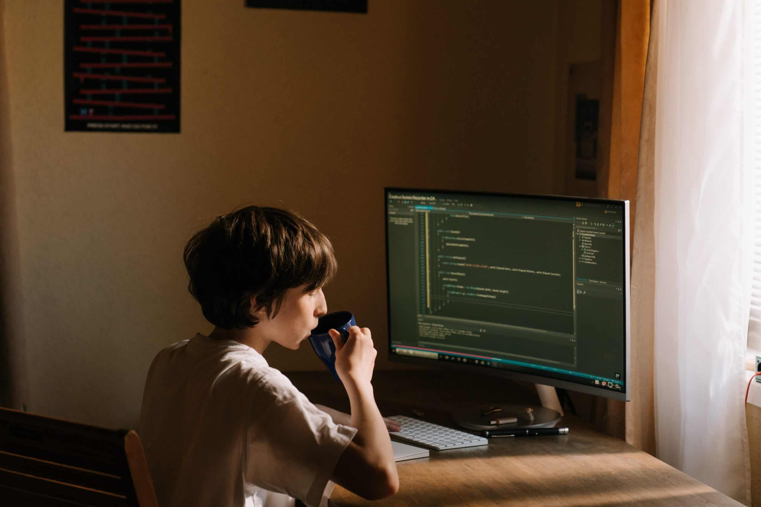 A person working on computer coding while discussing over a mobile phone in a home office setup. #Google My Business Profile