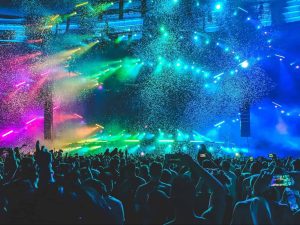 A dynamic concert scene with multicolored lights and confetti showering over an enthusiastic crowd.