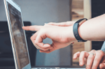 Person pointing at a laptop screen, indicating a focus on learning or teaching technology. #Tech-Savvy Students