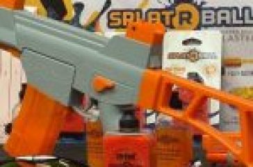 A toy splat ball gun in grey and orange with ammunition on a table against a colorful backdrop featuring the product name.