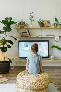 Child watching IP TV surrounded by houseplants