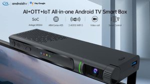 A sleek, black Android TV Smart Box with AI, OTT, and IoT capabilities, featuring a camera for video calls, mounted on a television. #Elderly Video Calling