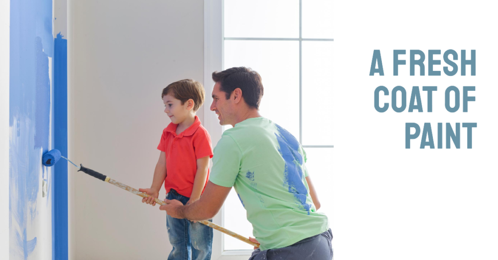 An adult and a child painting a wall blue together, with the text ‘A FRESH COAT OF PAINT’ above them