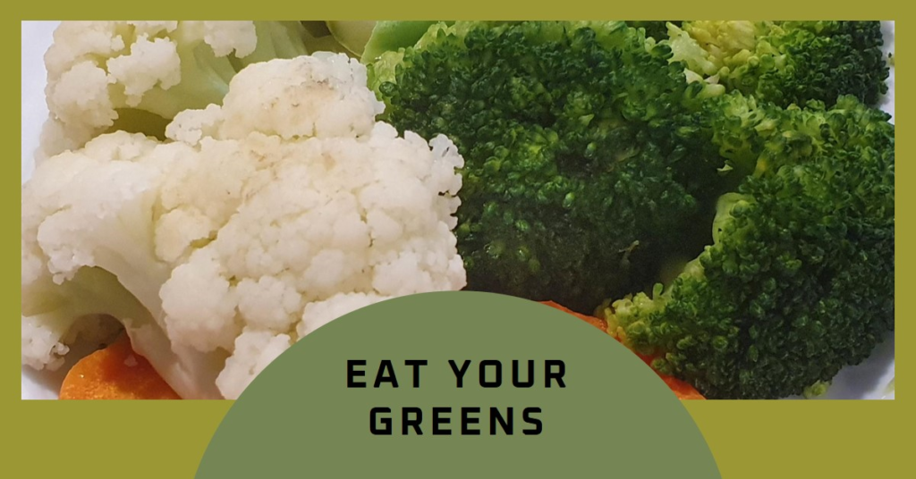 A pair of hands holding a light blue bowl filled with fresh spinach leaves against a dark grey background The spinach leaves are bright green and appear crisp indicating freshness