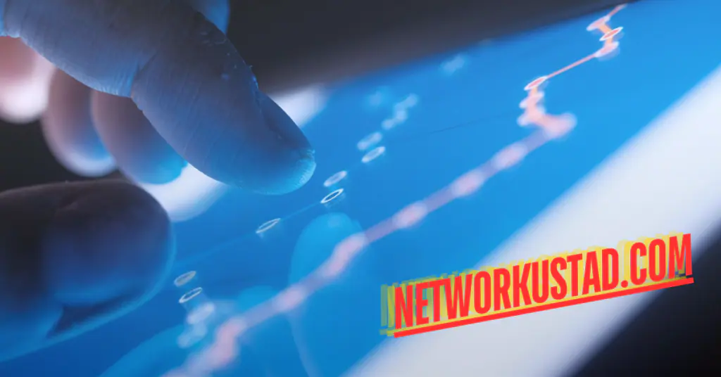  Close-up of a finger touching a digital tablet screen with graphical line charts and the text “NETWORKUSTAD.COM” in bold red letters. 