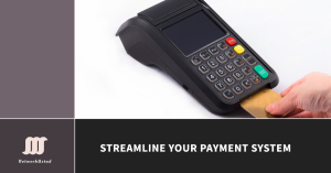 A hand inserting a credit card into a digital payment terminal, symbolizing streamlined payment solutions for small businesses.