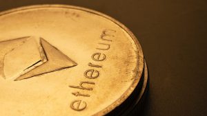 Close-up of an embossed Ethereum coin on a dark background.