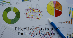A collection of various colorful charts and graphs on paper, including pie charts, a radar chart, and bar graphs, with a pencil resting on top. The text “Effective Customer Data Integration” is prominently displayed across the center.