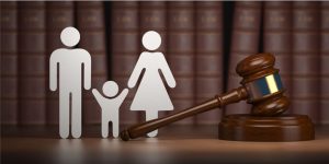 A gavel, representing the law, stands next to a family of three cutouts.