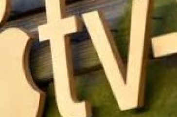 Apple TV+ logo on a wooden wall.