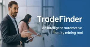 Car dealership sales professional holding tablet explaining TradeFinder equity mining tool to customer in showroom