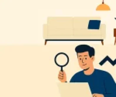 A person using a magnifying glass over a laptop with a rising arrow, symbolizing market research growth, in a cozy room with a sofa and plant.