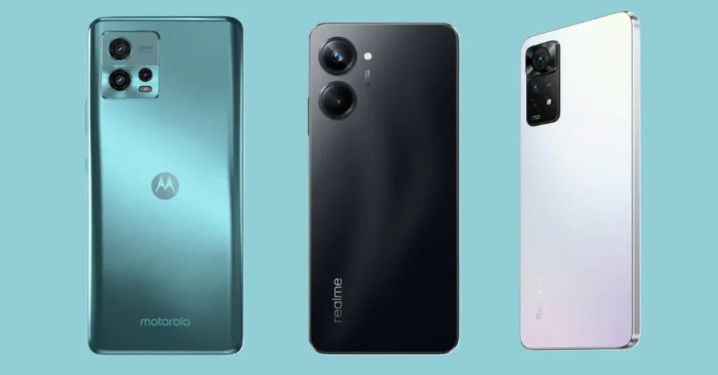 Three budget smartphones side by side: Motorola in teal, realme in black, and Redmi in white, showcasing rear designs and camera modules on a blue background.
